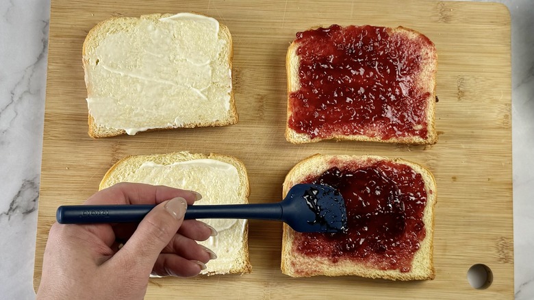 spreading jam on sandwich bread