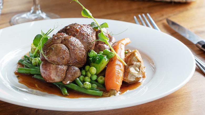 Cooked sweetbreads with peas and carrots