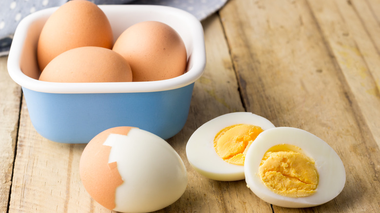 hard-boiled eggs in blue dish and on wooden table