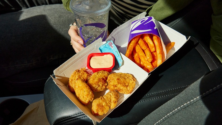 Taco Bell chicken nuggets and ranch with fries on a car's center console