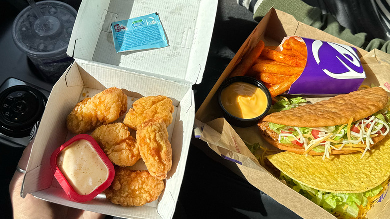 Taco bell chicken nuggets with ranch sauce and box of other taco bell foods