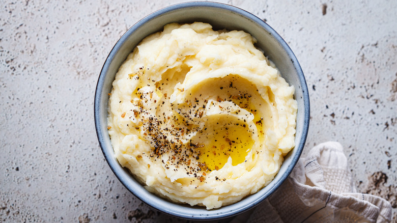 A bowl of mashed potatoes with butter and seasonings