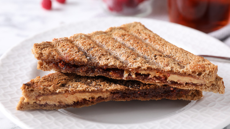 A sliced grilled peanut butter and jam sandwich on a plate.