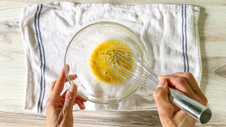 hands whisking sauce in bowl