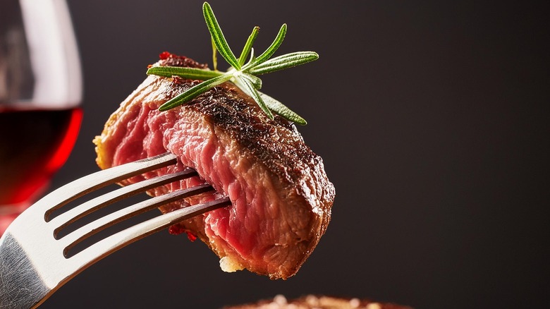 A slice of ribeye topped with rosemary sprig