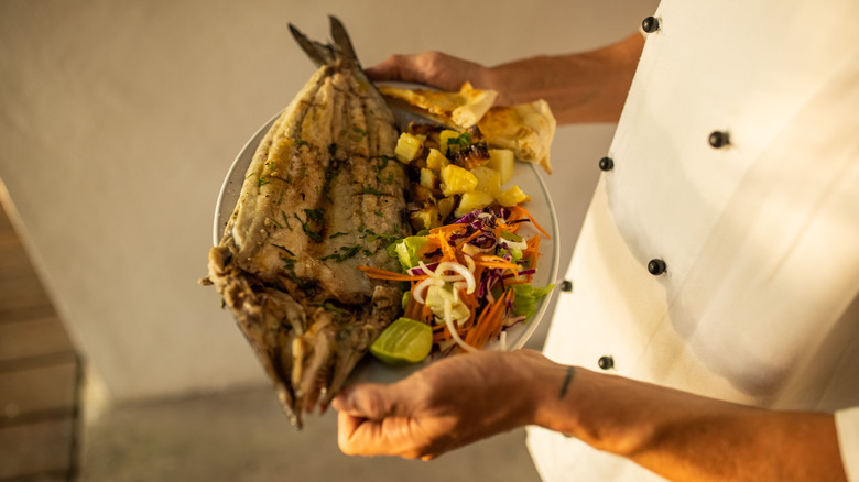 Chef holding fish dish