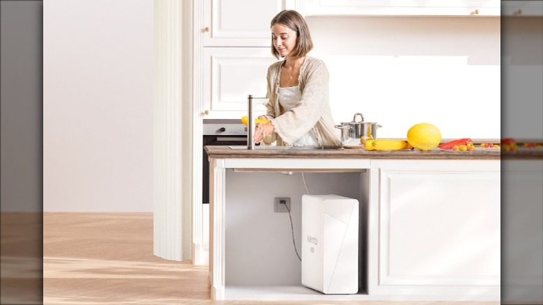 Woman using under the sink Waterdrop RO filter