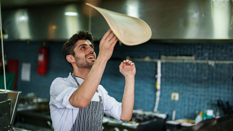 Chef tossing pizza dough in the air