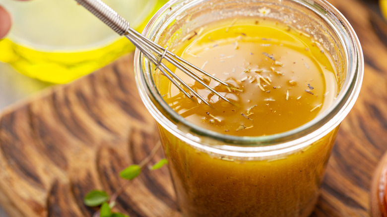 Italian vinaigrette dressing in a jar with a mini whisk