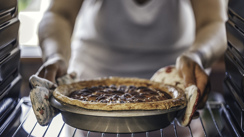 Pulling pie out of oven