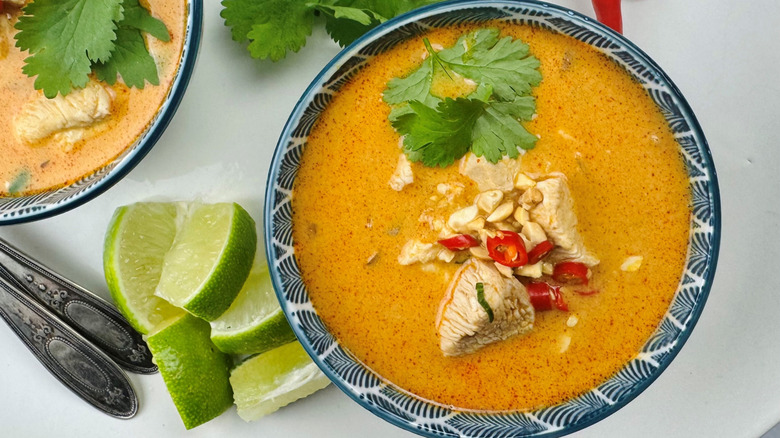 Thai peanut soup in bowl with garnishes