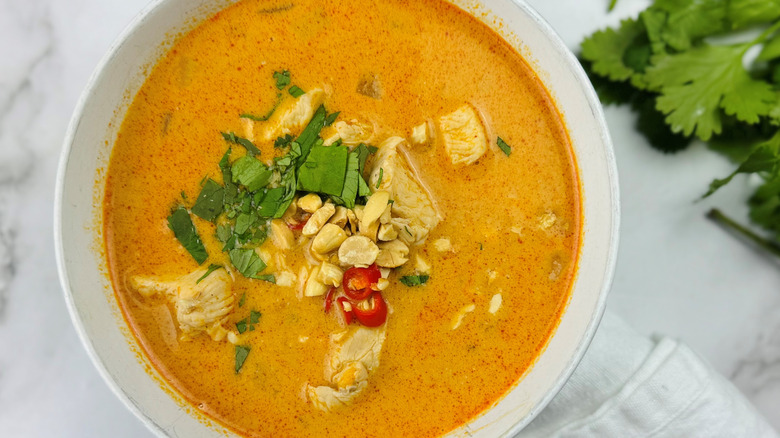 Bowl of Thai peanut soup with garnishes