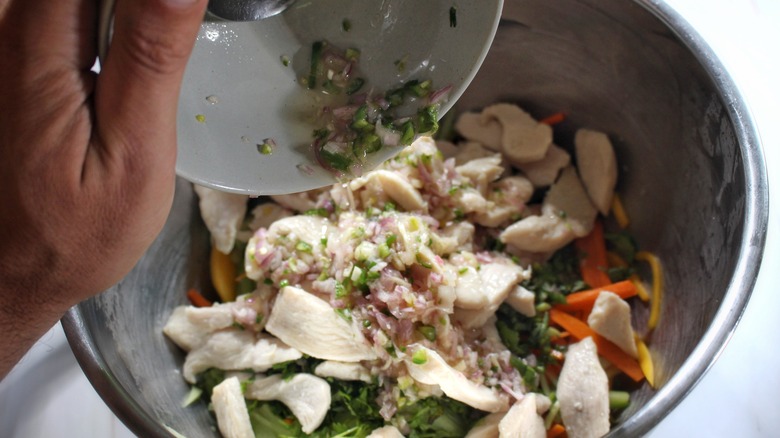 dressing pouring into chicken salad