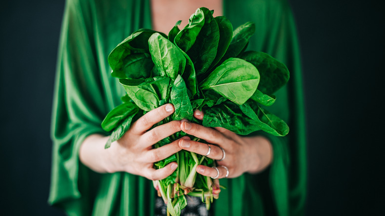 woman holding fresh spinach