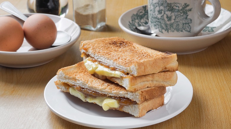 Kaya toast, eggs, and coffee cup on wooden table