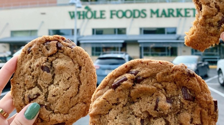 hands holding chocolate chip cookies