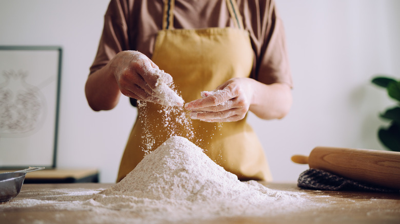 a woman in front of a pile of flour