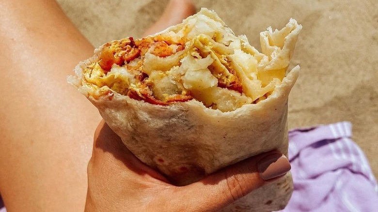 hand holding eaten burrito