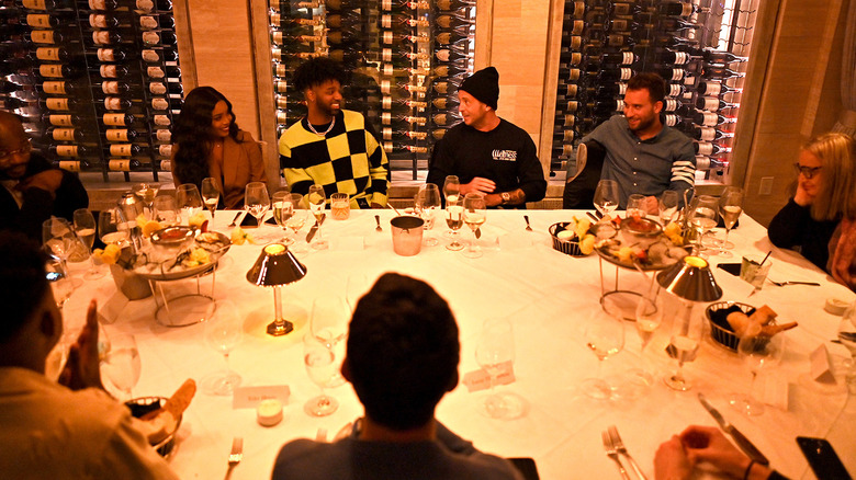 a group of celebrities at Mastro's Steakhouse dining in front of several wine bottles