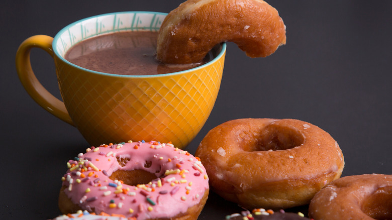 Donut half-dunked into a cup of mocha