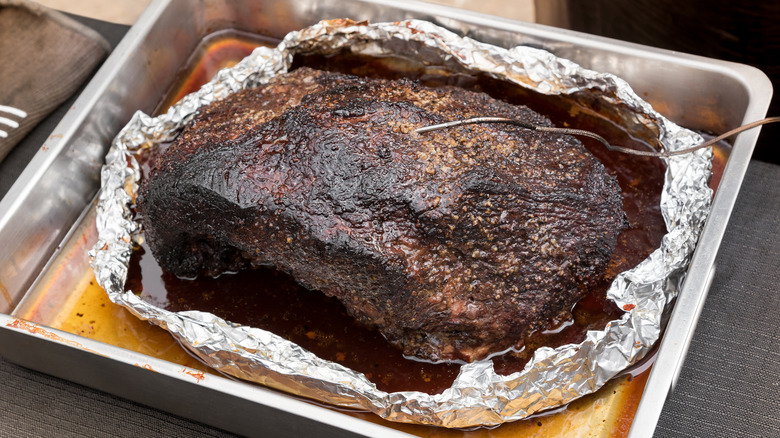 Cooked brisket in foil in an oven tray