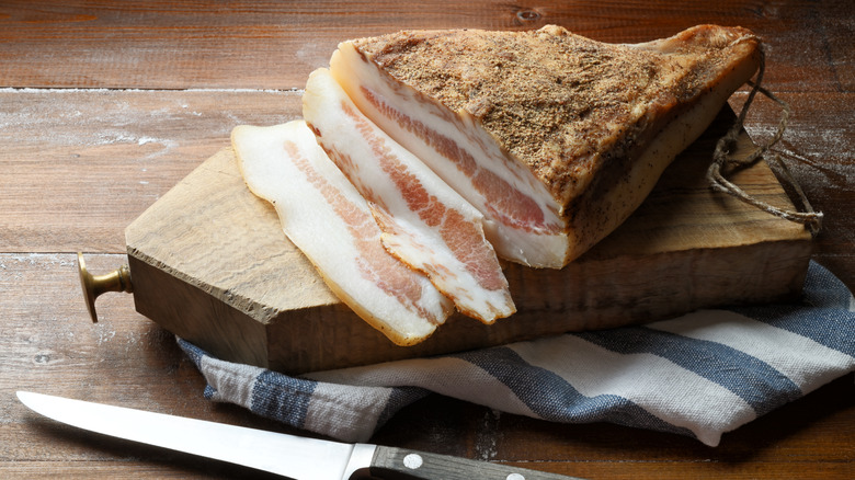 slice guanciale on rustic board