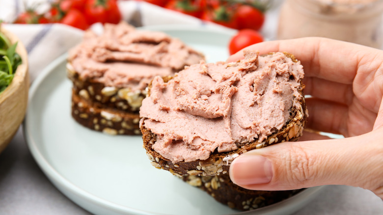 person holding liverwurst sandwich