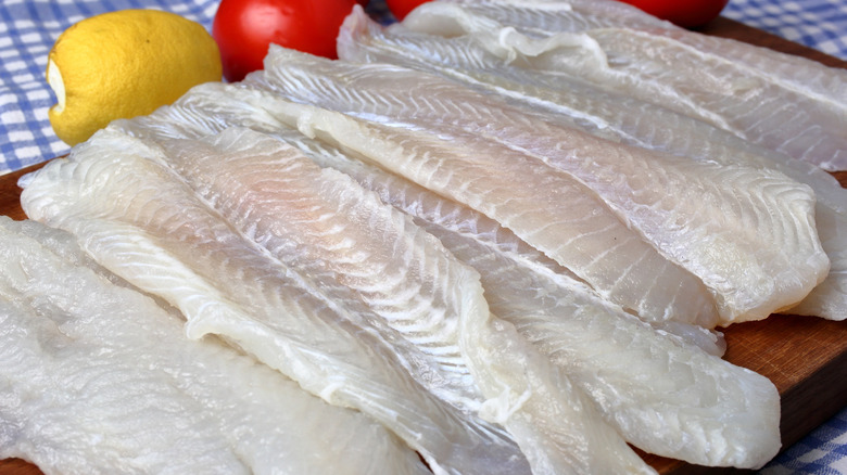 Sides of grouper are shown on a wooden cutting board.