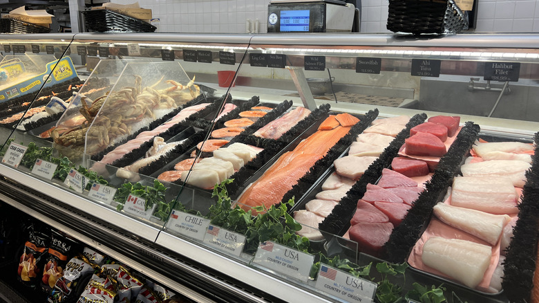 An angled shot shows a seafood counter at a grocery store.