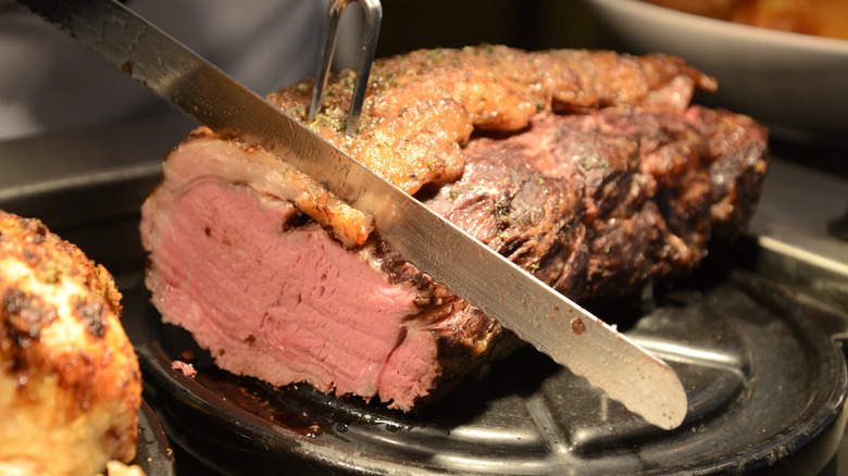 Carving knife slicing roasted meat