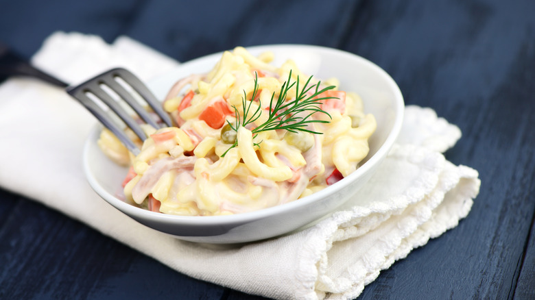 Creamy macaroni salad with dill garnish