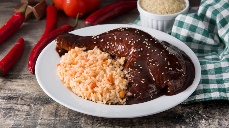 Mole poblano with chicken and rice on a white plate