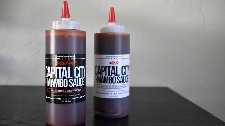 Sweet Hot and Mild mambo sauce bottles sit on a table