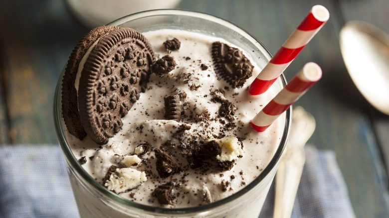 Cookies and cream milkshake with two red striped straws 