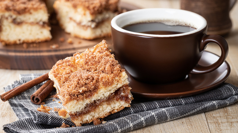 cinnamon coffee cake on a plate next to cup of coffee