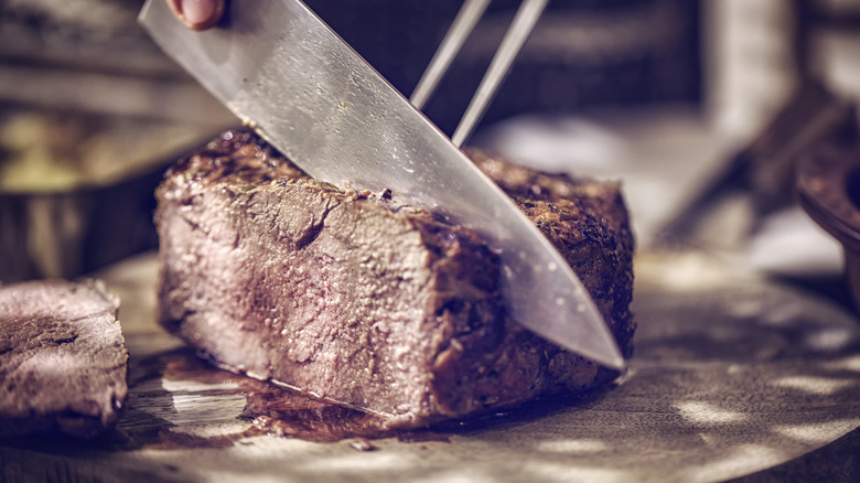 Person carving roast beef