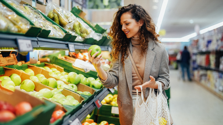 Woman shopping in produce section at grocery store