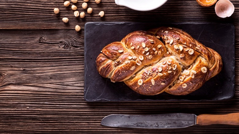 Braided bread load topped with nuts on slate slab