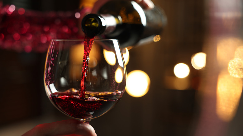 Bottle of red wine being poured into glass