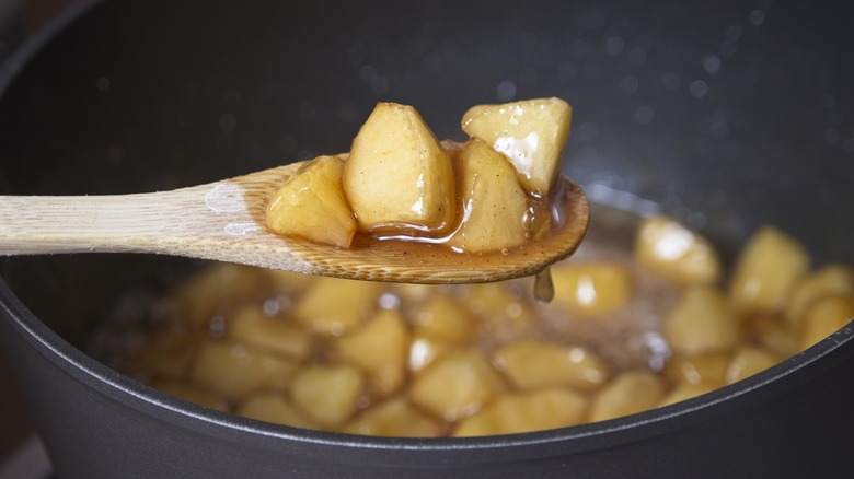 Cooked apples in wooden spoon