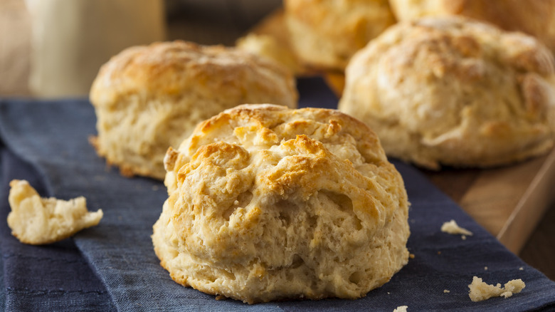 A batch of flaky buttermilk biscuits sit on a table