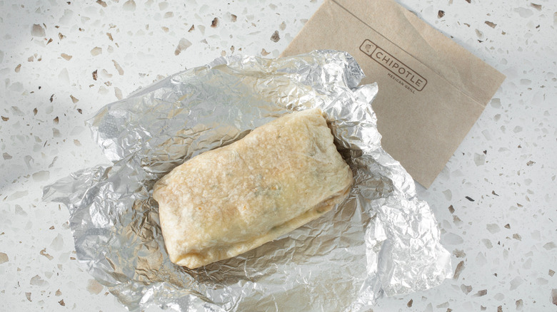 A Chipotle burrito sits underneath a Chipotle receipt