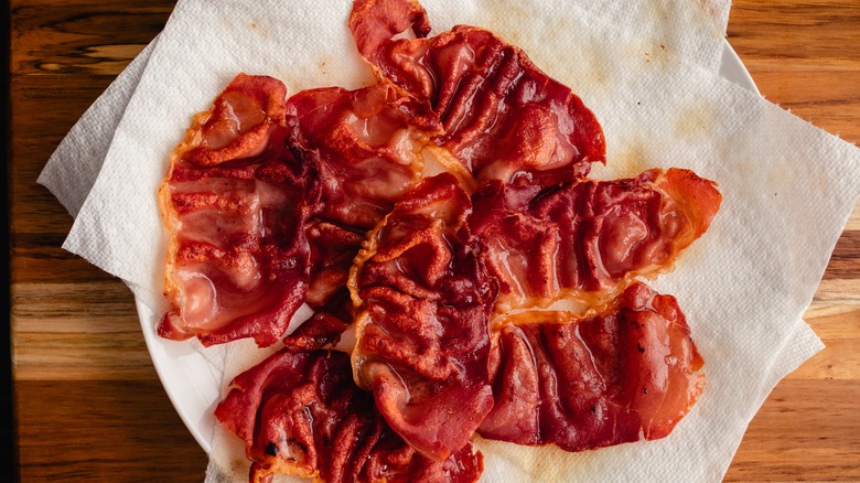 Crispy thin cooked slices of prosciutto draining on kitchen paper