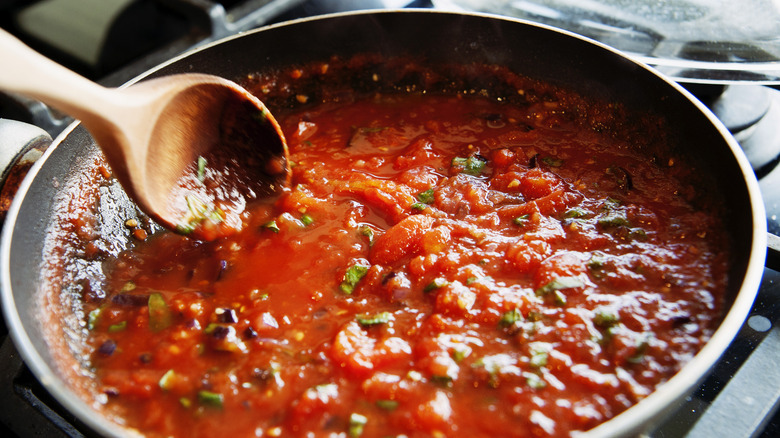 tomato sauce simmering in a black pan