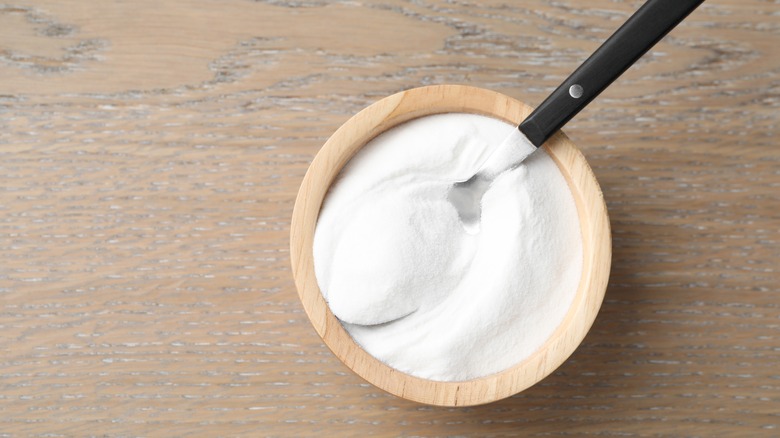 baking powder in a wooden bowl with spoon