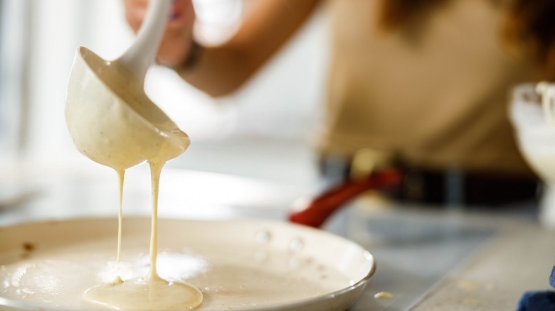 Person pouring batter onto a pan 