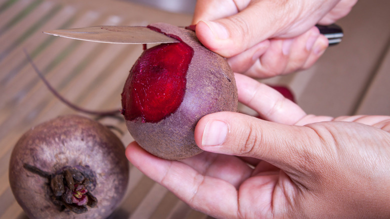 Person peeling beets with paring knife