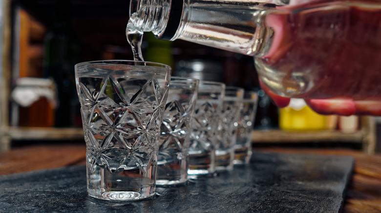 vodka being poured into shot glasses