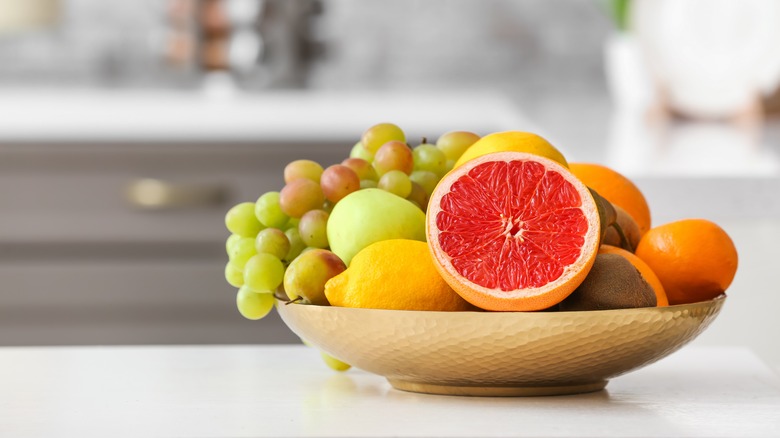 Halved grapefruit in bowl of various fruit