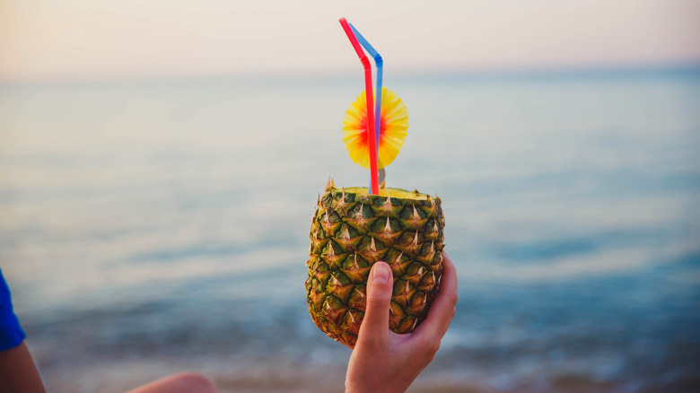 Hand holding pineapple cocktail